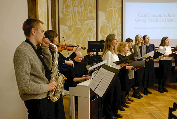 A man playing a saxophone in front of a group of people.

Description generated by AI