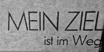 The text on a gray fabric reads "MEIN ZIEL ist im Weg" in bold black letters.

Description generated by AI