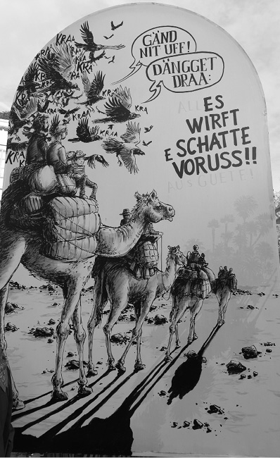 A group of people riding camels in a desert with birds flying overhead and speech bubbles containing German text.
Description generated by AI